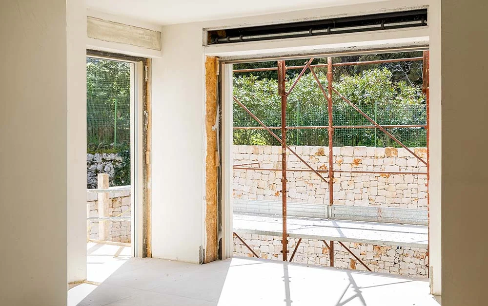Installazione e posa in cantiere di spalle termiche isolanti Multiform attorno a portafinestra in ristrutturazione